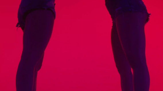 The legs of two women standing on opposite of the screen.